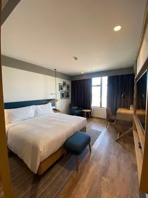 a hotel room with a large bed and a chair at Hilton Garden Inn Casablanca Sud in Casablanca