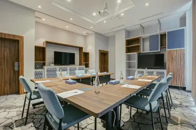 a conference room with a large wooden table and chairs at Hilton Garden Inn Casablanca Sud in Casablanca