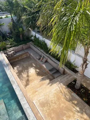 a swimming pool with a palm tree next to it at Skhirat VILLA Zhor in Skhirat