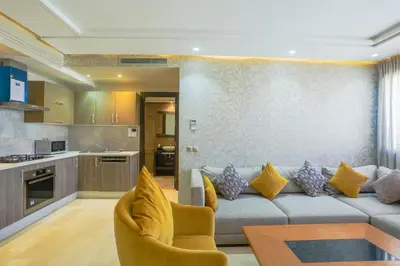a living room with a couch and a kitchen at Massira Diamond Maarif- Parking-wifi-self check in in Casablanca