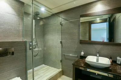 a bathroom with a shower and a sink and a glass shower stall at Massira Diamond Maarif- Parking-wifi-self check in in Casablanca