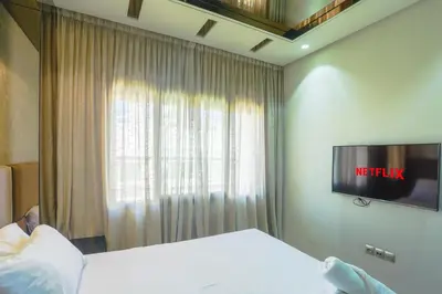 a bedroom with a bed and a television on a wall at Massira Diamond Maarif- Parking-wifi-self check in in Casablanca