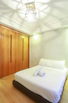 a bedroom with a large white bed and wooden cabinets at Racine spacious 2 bedrooms near twin center#Freewifi#freeparking in Casablanca