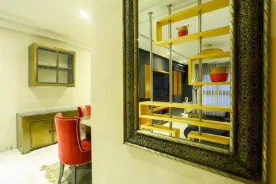 a mirror on a wall next to a red chair at Racine spacious 2 bedrooms near twin center#Freewifi#freeparking in Casablanca