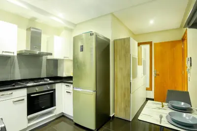 a kitchen with a refrigerator and a table in it at Racine spacious 2 bedrooms near twin center#Freewifi#freeparking in Casablanca