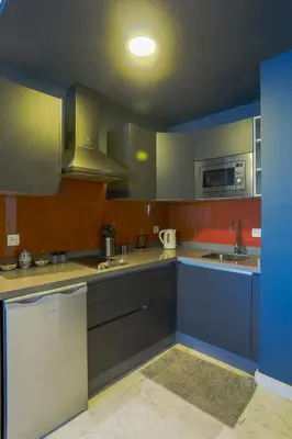 a kitchen with blue and gray cabinets and a sink at Lavish Flat in new city #fastwifi#Parking in Casablanca