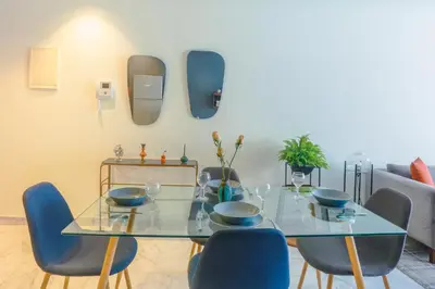 a dining room with a glass table and blue chairs at Lavish Flat in new city #fastwifi#Parking in Casablanca