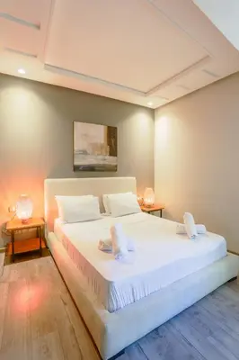 a bedroom with a large white bed and two tables at Royal Massira flat in shopping center#wifi#parking in Casablanca