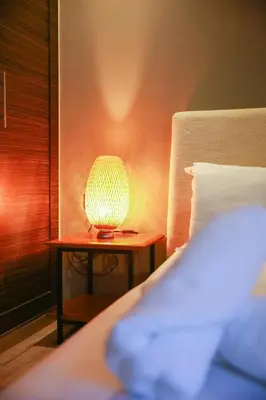 a lamp sitting on a table next to a bed at Royal Massira flat in shopping center#wifi#parking in Casablanca