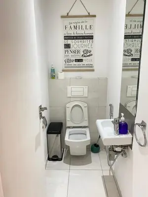 a white bathroom with a toilet and a sink at GREEN HOUSE OVERLOOKING INTERNATIONAL SCHOOL in Casablanca