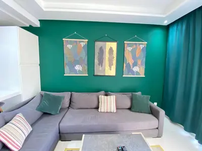 a living room with a couch and a green wall at GREEN HOUSE OVERLOOKING INTERNATIONAL SCHOOL in Casablanca