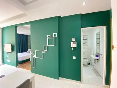 a bathroom with a green wall with a ladder to a toilet at GREEN HOUSE OVERLOOKING INTERNATIONAL SCHOOL in Casablanca