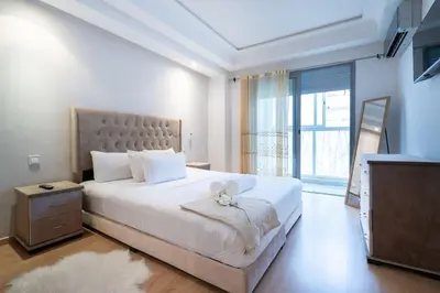 a bedroom with a large white bed with a teddy bear on it at Racine Two bedroom flat near twin center in Casablanca