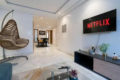 a living room with a television on a wall at Racine Two bedroom flat near twin center in Casablanca