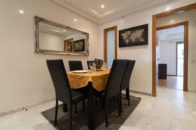 a dining room with a table with chairs and a mirror at Racine Two bedroom flat near twin center in Casablanca