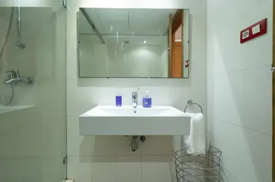 a bathroom with a white sink and a mirror at Racine bd anfa Appart style tokyo near twin center in Casablanca