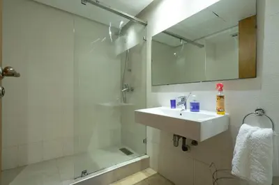a white bathroom with a sink and a shower at Racine bd anfa Appart style tokyo near twin center in Casablanca