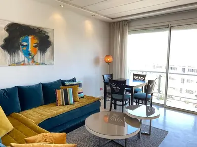 a living room with a blue couch and a table at Racine bd anfa Appart style tokyo near twin center in Casablanca