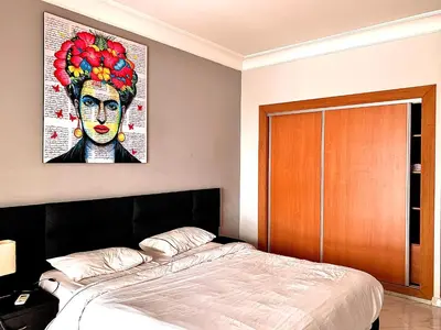 a bedroom with a bed with a painting on the wall at Anfa 118 - Best view in town - 3 bedrooms - 2 Bathrooms in Casablanca
