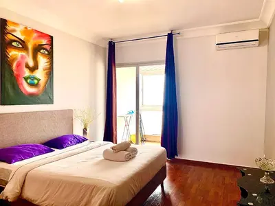 a bedroom with two beds with purple pillows and a painting at Anfa 118 - Best view in town - 3 bedrooms - 2 Bathrooms in Casablanca