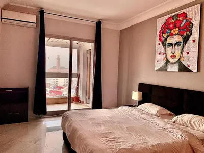 a bedroom with a bed and a painting of a woman at Anfa 118 - Best view in town - 3 bedrooms - 2 Bathrooms in Casablanca