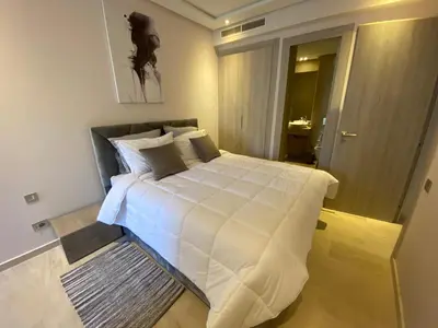 a bedroom with a large bed with white sheets at Très beau studio à Ain Diab in Casablanca