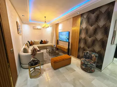a living room with a couch and a tv at luxury apartment opposite HASSAN 2 MOSQU and FAIR international casablanca and SEA , near downtwn , INTERDIT COUPLES ARAABIC NON MARIÈ, FORBIDDEN UNMARRIED ARAABIC COUPLES , 2 room, 2 living rooms and 2 bathrooms basement car park FREE , apartment with in Casablanca