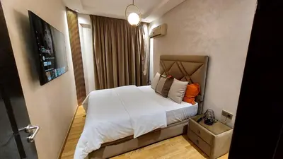 a bedroom with a large bed with white sheets at luxury apartment opposite HASSAN 2 MOSQU and FAIR international casablanca and SEA , near downtwn , INTERDIT COUPLES ARAABIC NON MARIÈ, FORBIDDEN UNMARRIED ARAABIC COUPLES , 2 room, 2 living rooms and 2 bathrooms basement car park FREE , apartment with in Casablanca