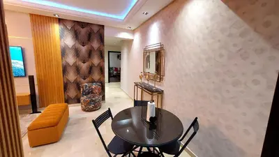 a dining room with a black table and chairs at luxury apartment opposite HASSAN 2 MOSQU and FAIR international casablanca and SEA , near downtwn , INTERDIT COUPLES ARAABIC NON MARIÈ, FORBIDDEN UNMARRIED ARAABIC COUPLES , 2 room, 2 living rooms and 2 bathrooms basement car park FREE , apartment with in Casablanca