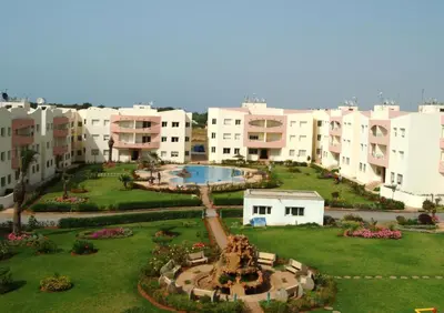 a large building with a courtyard with a fountain at Les vagues douces de Mohammedia in Mohammedia