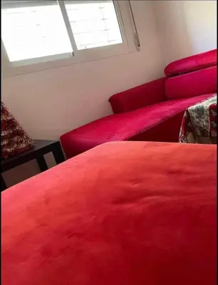 a room with two red beds and a window at Lovely 1-Bed Apartment in Skhirat in Skhirat