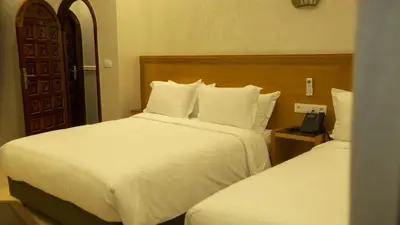 a hotel room with two beds and a telephone at Hotel de paris in Casablanca