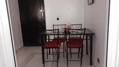 a dining room table with four red chairs at Paradise house in Casablanca