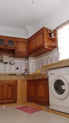 a kitchen with wooden cabinets and a washing machine at Paradise house in Casablanca