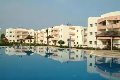 a large pool in front of some apartment buildings at Appartement sable et soleil in Mohammedia