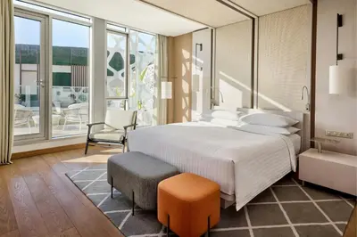 a bedroom with a large white bed and a chair at Rabat Marriott Hotel in Rabat