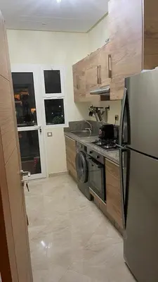 a kitchen with a stove and a refrigerator at CASA BAY BEACH OMK in Sidi Rahal