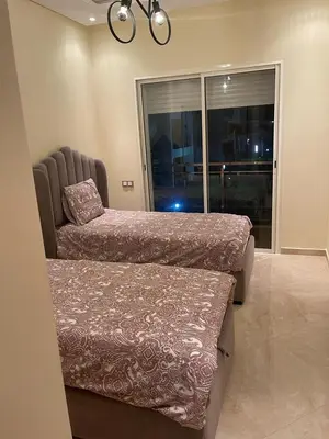 a bedroom with two beds and a large window at CASA BAY BEACH OMK in Sidi Rahal
