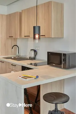 a kitchen with a microwave and a counter with a stool at Stayhere Casablanca - Palmier - Executive Residence in Casablanca