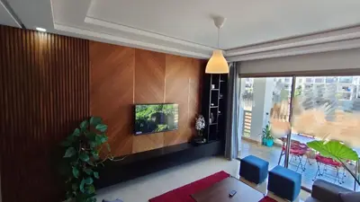 a living room with a tv on a wall at bouzkina Costa beach golf in Bouznika