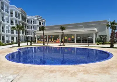 a large blue swimming pool in front of a building at bouzkina Costa beach golf in Bouznika