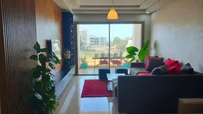 a living room with a couch and a red rug at bouzkina Costa beach golf in Bouznika