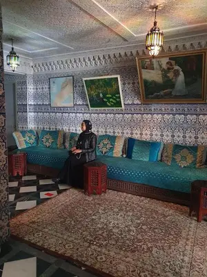 a woman sitting on a couch in a living room at HOTEL DU LOUVRE in Casablanca