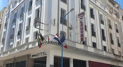 a large white building with flags in front of it at HOTEL DU LOUVRE in Casablanca