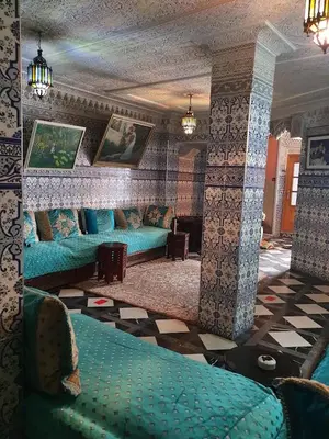 a living room with blue couches and a fireplace at HOTEL DU LOUVRE in Casablanca