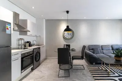 a kitchen and living room with a couch and a table at Gauthier Living by ShortStayMaroc, Appartement Équipé, Centre, 1 ou 2 Chambres in Casablanca