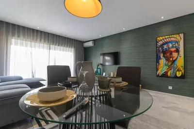 a living room with a glass table and a couch at Gauthier Living by ShortStayMaroc, Appartement Équipé, Centre, 1 ou 2 Chambres in Casablanca