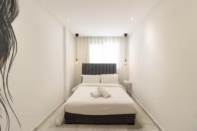 a bedroom with a bed in a white room at Gauthier Living by ShortStayMaroc, Appartement Équipé, Centre, 1 ou 2 Chambres in Casablanca