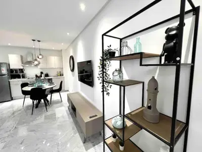a living room with a table and a kitchen at Gauthier Living by ShortStayMaroc, Appartement Équipé, Centre, 1 ou 2 Chambres in Casablanca