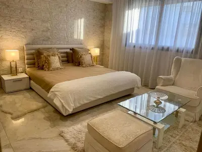 a bedroom with a bed and a chair and a table at #10 Racine triangle d or near aindiab in Casablanca